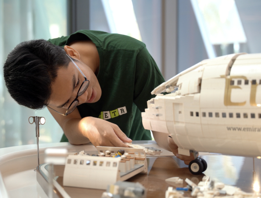 A Tetr student assembling a scale aircraft model on campus
